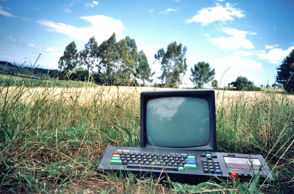 un papier peint avec un Amstrad CPC 464 en plein nature